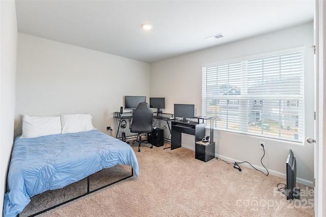 bedroom with multiple windows and light carpet