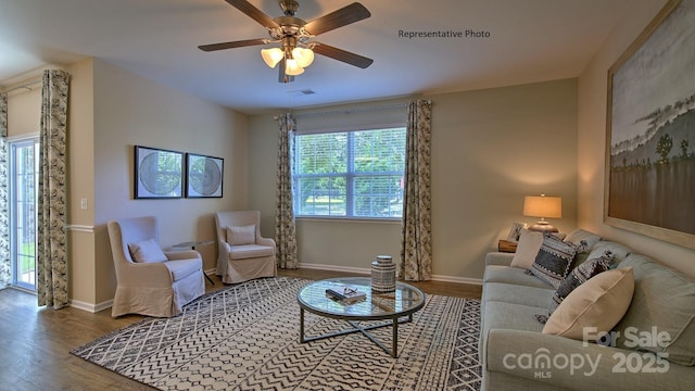 living area featuring visible vents, wood finished floors, baseboards, and ceiling fan