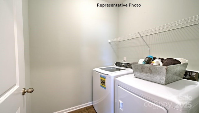 laundry area with laundry area, washing machine and dryer, and baseboards