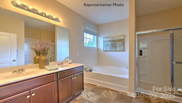 bathroom featuring a bath, a stall shower, and a sink