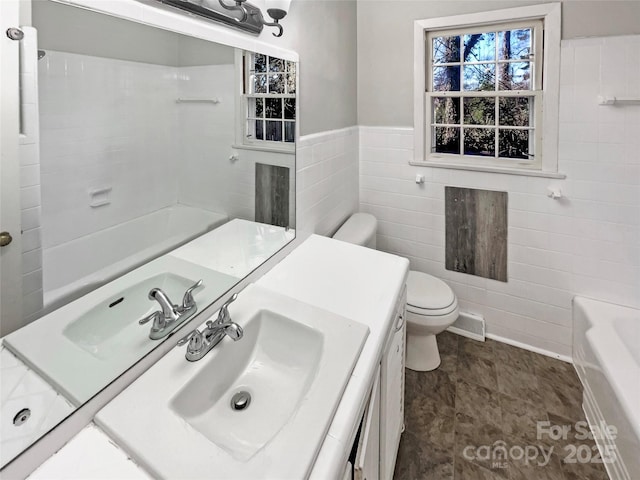 bathroom featuring vanity, tile walls, and toilet