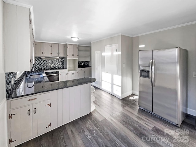 kitchen featuring oven, crown molding, kitchen peninsula, stainless steel refrigerator with ice dispenser, and dark wood-type flooring