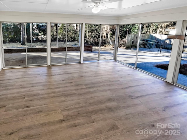 unfurnished sunroom with ceiling fan