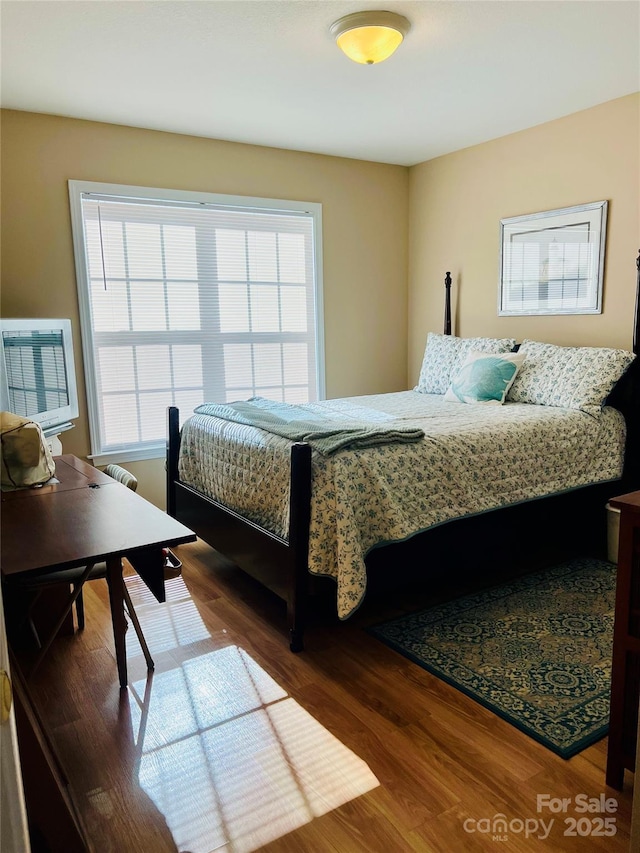 bedroom with dark hardwood / wood-style flooring and multiple windows