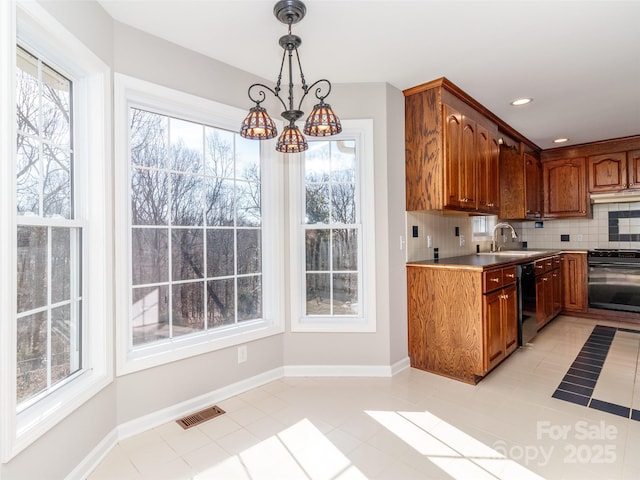 kitchen featuring hanging light fixtures, plenty of natural light, backsplash, and black appliances