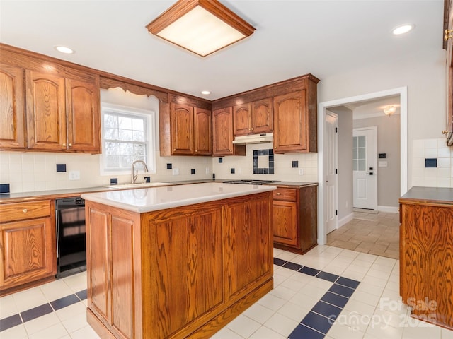 kitchen with tasteful backsplash, a center island, sink, and light tile patterned floors