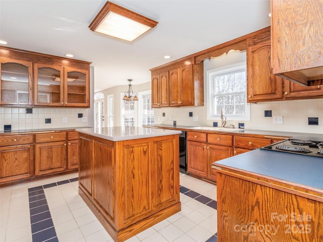 kitchen featuring stovetop, hanging light fixtures, tasteful backsplash, and a center island