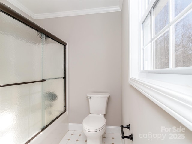 bathroom with crown molding, combined bath / shower with glass door, and toilet