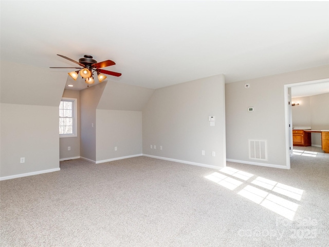 interior space with ceiling fan, lofted ceiling, and light carpet