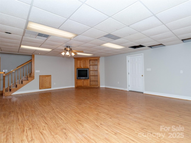 unfurnished living room featuring a paneled ceiling, ceiling fan, and light wood-type flooring