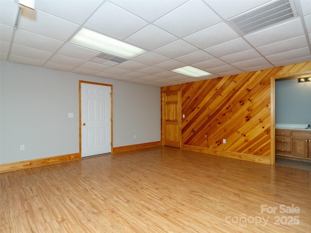 interior space featuring hardwood / wood-style flooring, wooden walls, and a paneled ceiling