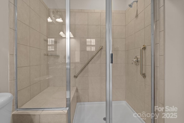 bathroom with a shower stall and toilet