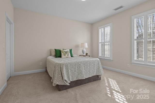 carpeted bedroom with visible vents and baseboards