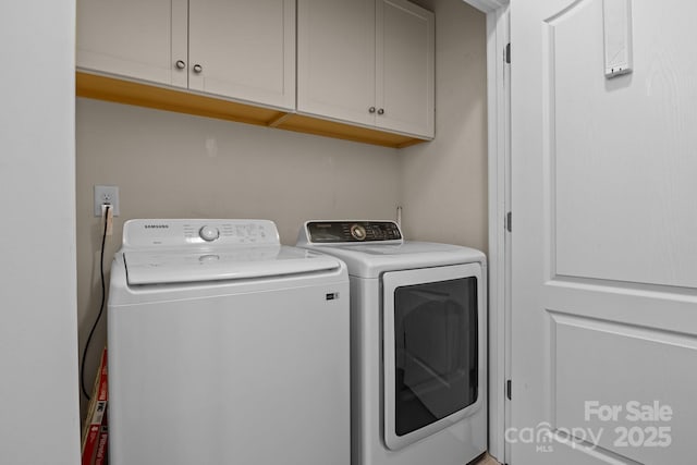 washroom featuring cabinet space and washer and dryer