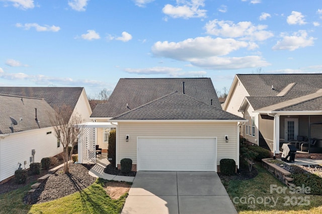 view of front of home featuring a garage, driveway, and a shingled roof