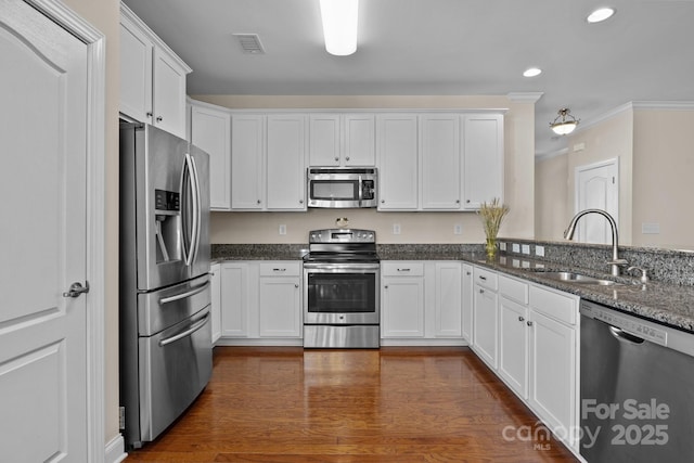 kitchen with white cabinetry, visible vents, stainless steel appliances, and a sink