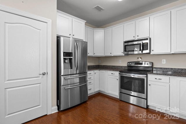 kitchen featuring visible vents, appliances with stainless steel finishes, white cabinets, and dark wood-style flooring