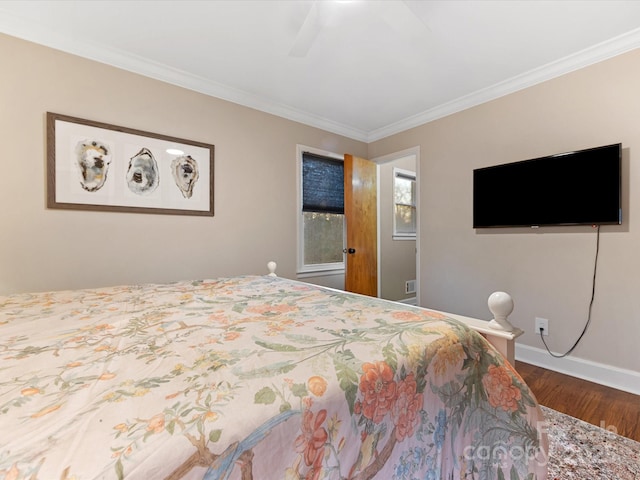 bedroom with hardwood / wood-style flooring, crown molding, and ceiling fan