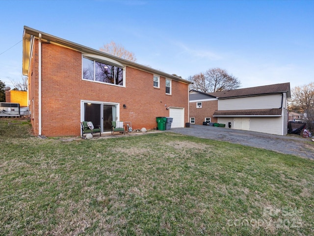 back of property featuring a garage and a yard