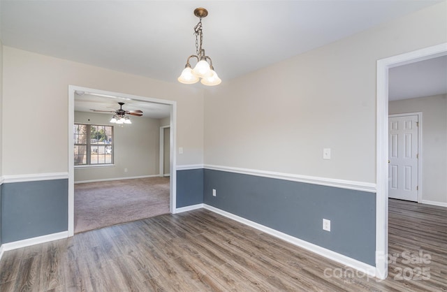 unfurnished room with dark wood-type flooring and ceiling fan with notable chandelier