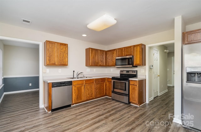 kitchen featuring stainless steel appliances, dark hardwood / wood-style flooring, and sink