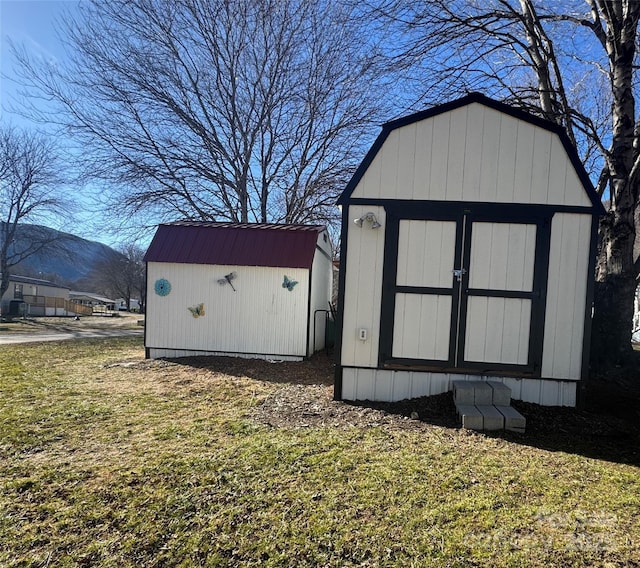 view of outdoor structure with a mountain view and a lawn