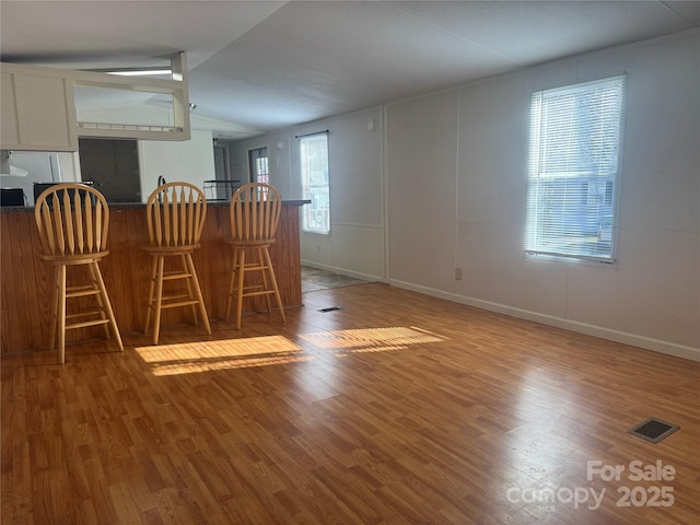 unfurnished dining area featuring lofted ceiling and light hardwood / wood-style floors