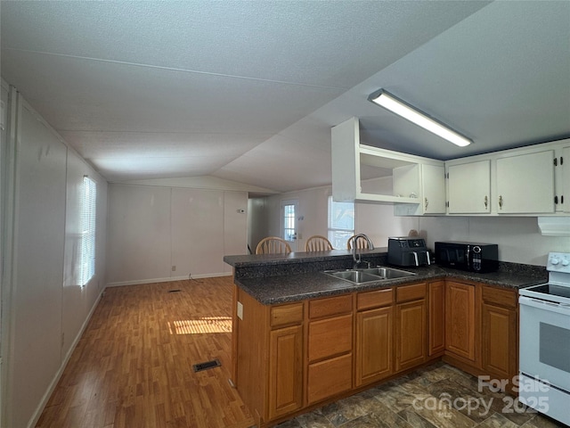 kitchen with dark wood-type flooring, lofted ceiling, white electric range, sink, and kitchen peninsula