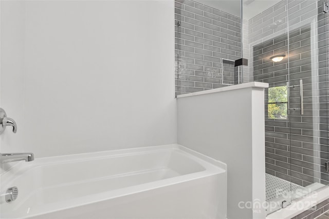 bathroom featuring separate shower and tub