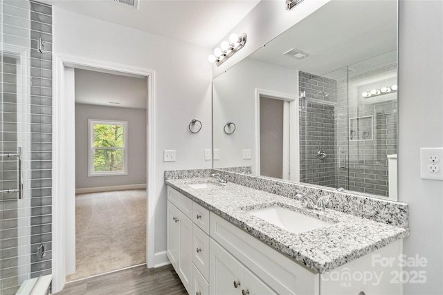 bathroom featuring walk in shower, vanity, and hardwood / wood-style floors