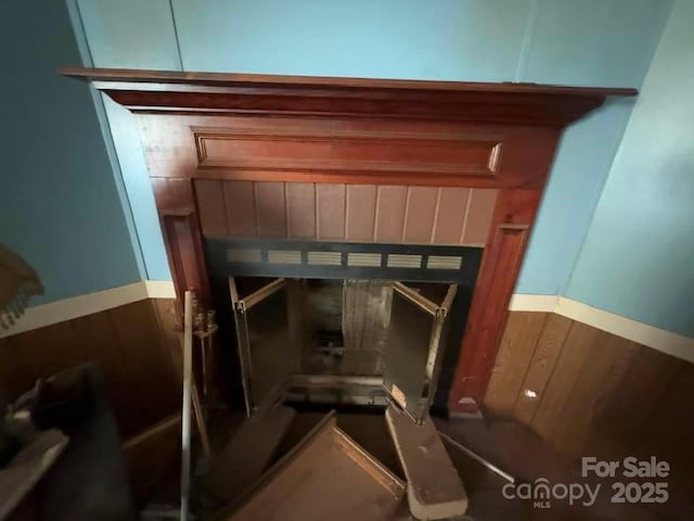 room details with a tile fireplace and wood walls