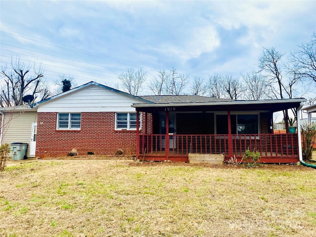 ranch-style home featuring covered porch and a front lawn