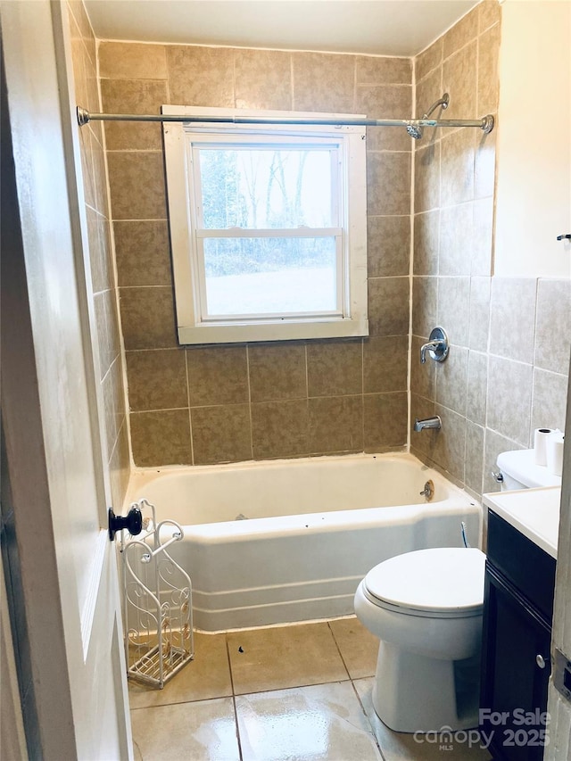 full bathroom featuring tile patterned floors, toilet, tiled shower / bath combo, and vanity