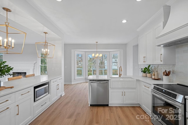 kitchen featuring custom exhaust hood, sink, pendant lighting, and stainless steel appliances