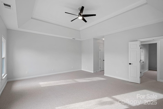 unfurnished bedroom with a raised ceiling, crown molding, and light carpet