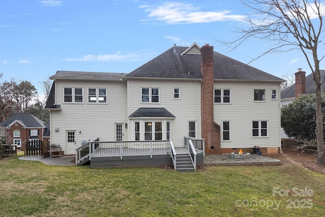 back of house featuring a wooden deck and a lawn