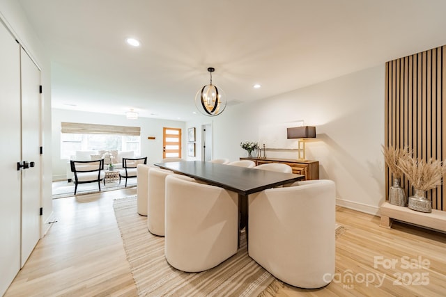 dining area featuring light wood-type flooring, baseboards, recessed lighting, and an inviting chandelier