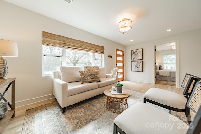 living room with recessed lighting, baseboards, and light wood finished floors