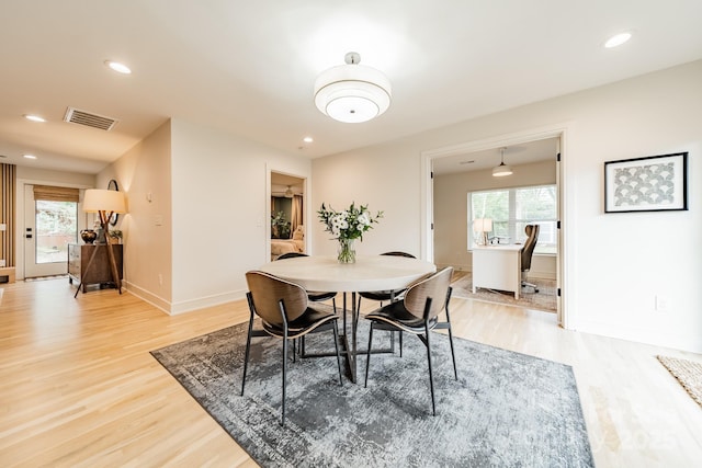 dining room featuring visible vents, plenty of natural light, and light wood finished floors