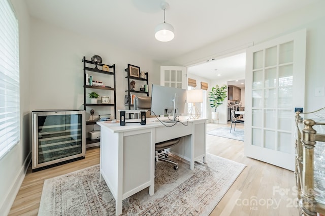 office space featuring beverage cooler and light wood finished floors