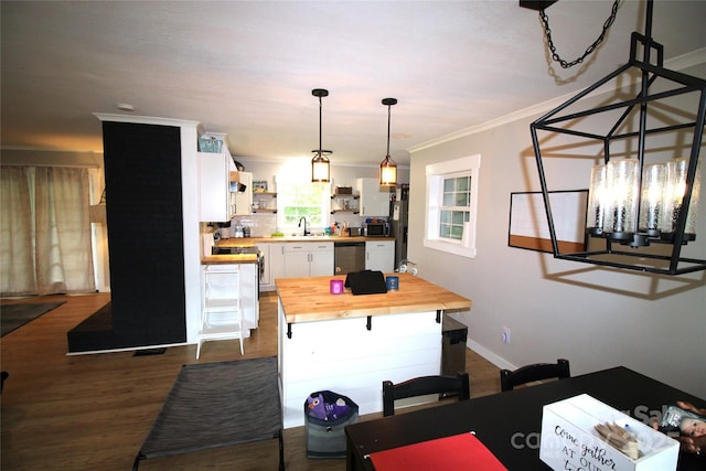 dining space featuring sink, crown molding, and hardwood / wood-style floors