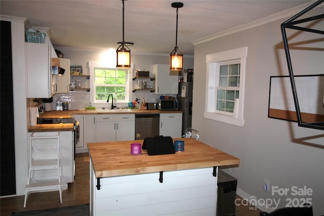 kitchen with appliances with stainless steel finishes, wood counters, white cabinetry, sink, and hanging light fixtures