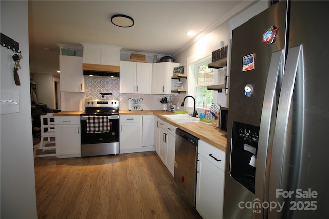 kitchen featuring sink, stainless steel appliances, wooden counters, and white cabinets