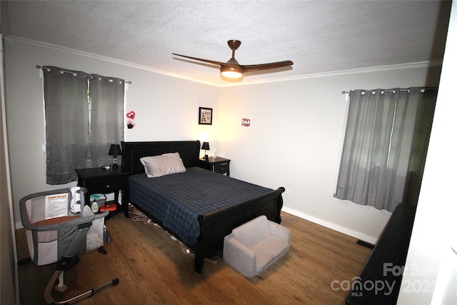 bedroom with ceiling fan, ornamental molding, dark hardwood / wood-style floors, and a textured ceiling