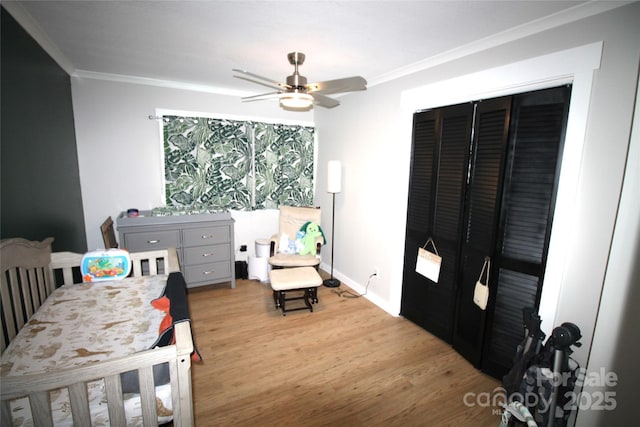 bedroom featuring a closet, ornamental molding, light hardwood / wood-style floors, and ceiling fan