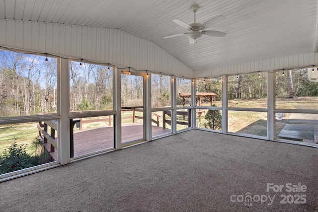 unfurnished sunroom with a ceiling fan and vaulted ceiling