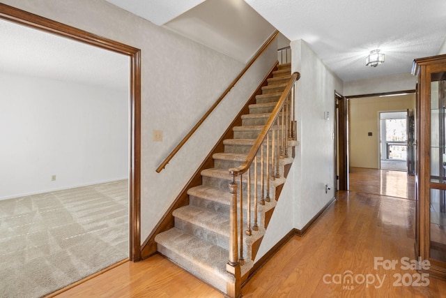 stairs with baseboards and wood finished floors