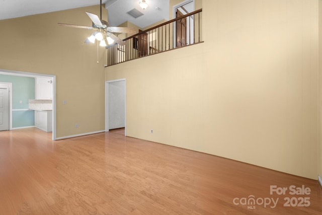 unfurnished living room featuring high vaulted ceiling, ceiling fan, visible vents, and wood finished floors