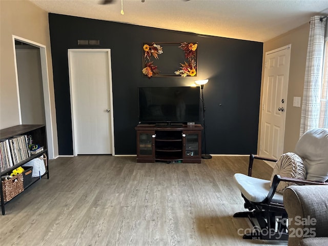 sitting room featuring hardwood / wood-style flooring and vaulted ceiling