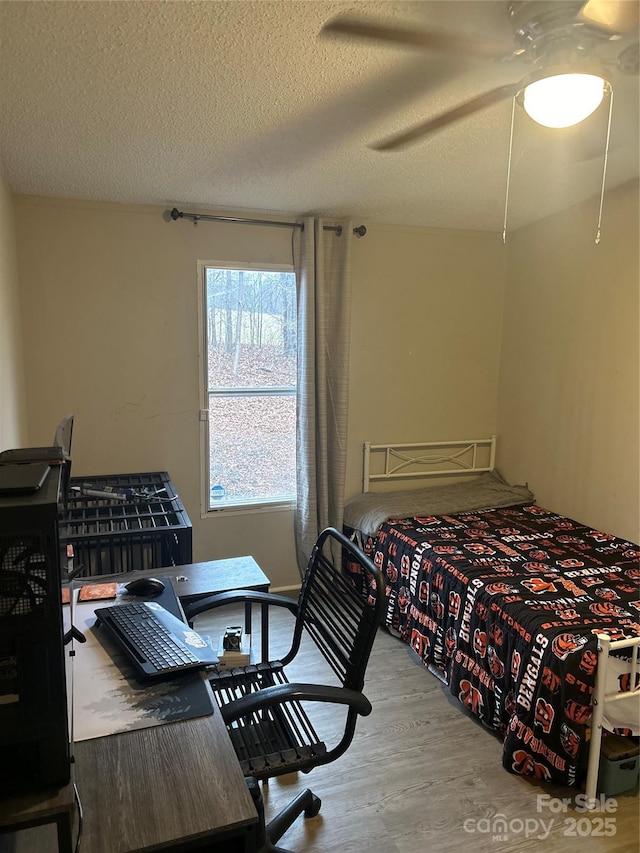 bedroom featuring wood-type flooring and a textured ceiling